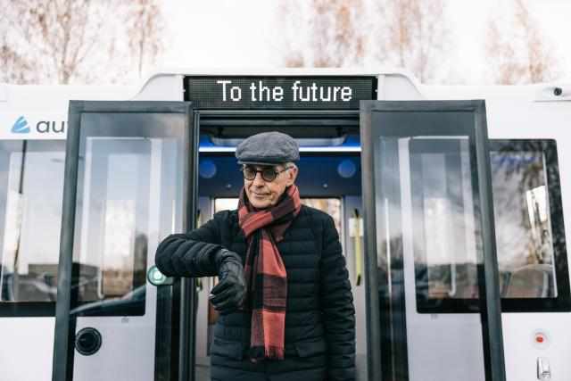 Man Standing in Front of Self Driving Bus