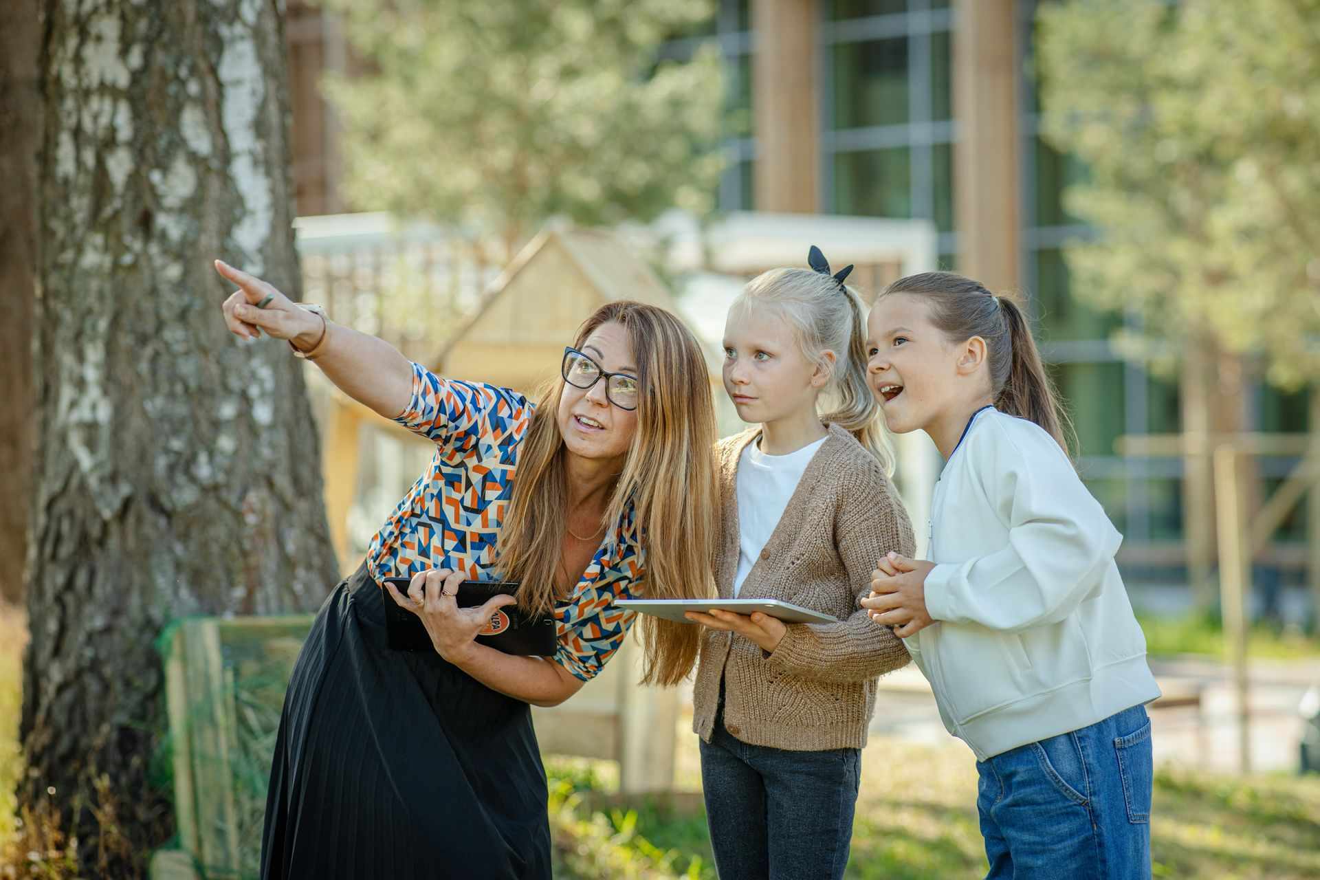 655528 Teacher Guiding Students Outdoors With Tablet Web Version 1920px (1)