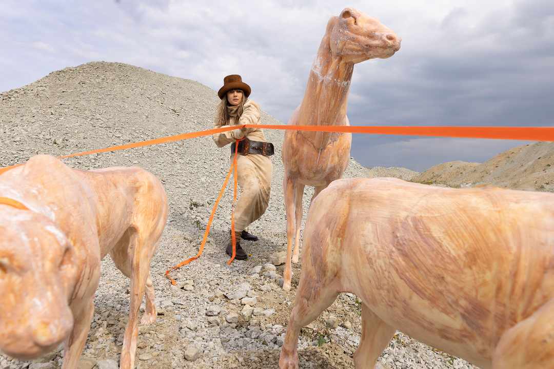 Edith Karlson outdoors with sculptural animal figures